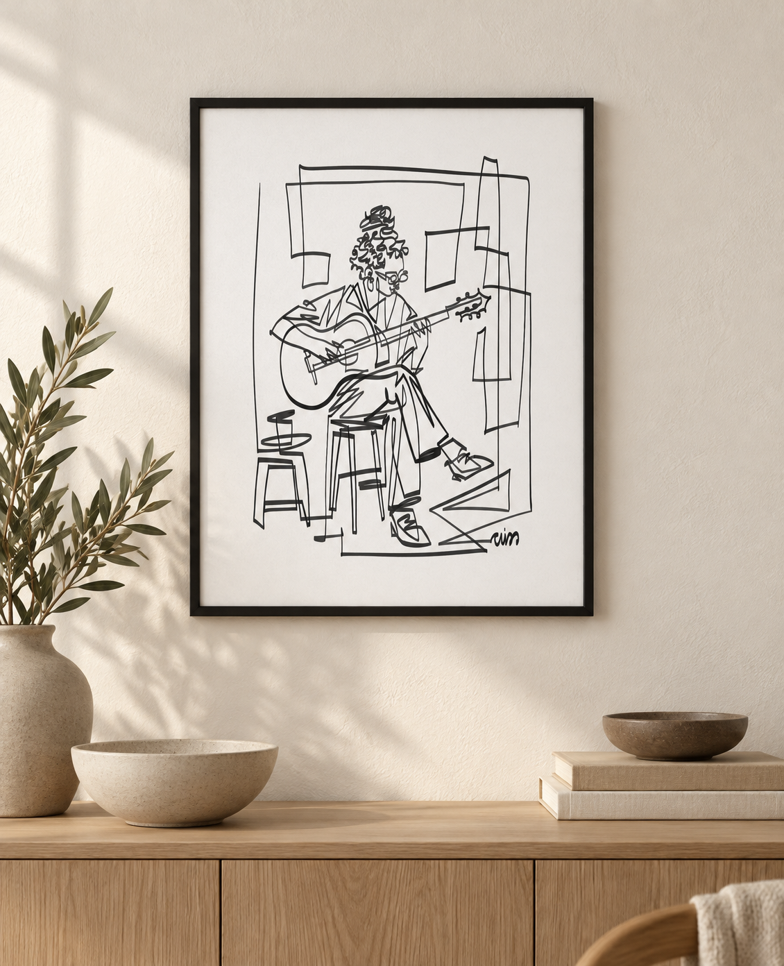 Single Line Guitarist art print in a black frame above an oak console. Illustrative interior; frame not included.